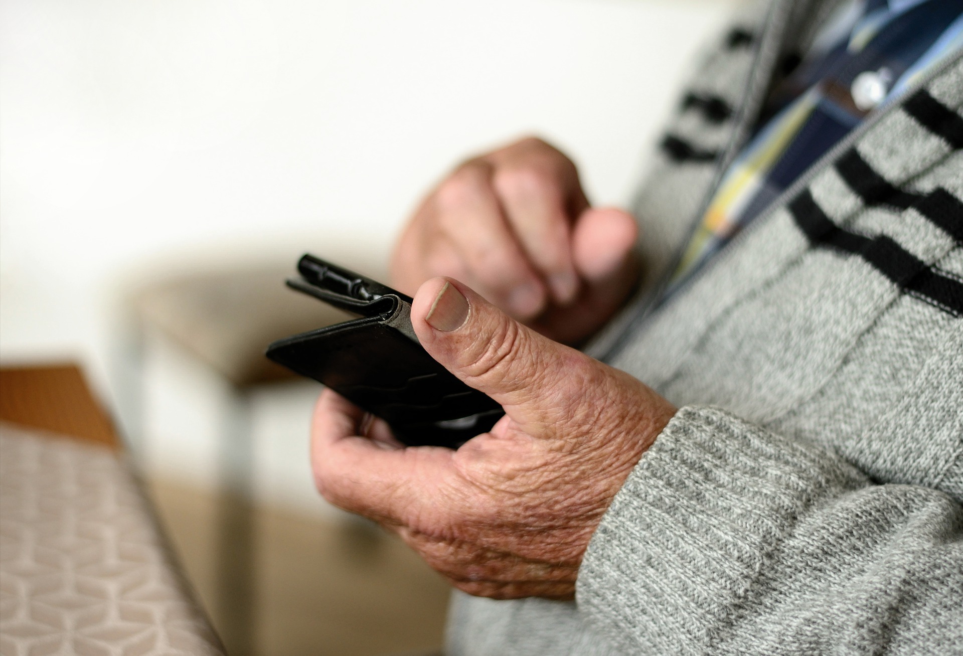 Seniorikansalainen älypuhelin kädessä